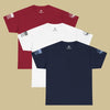 Red t shirt, white t shirt, and blue t shirt overlapping, on a beige colored background